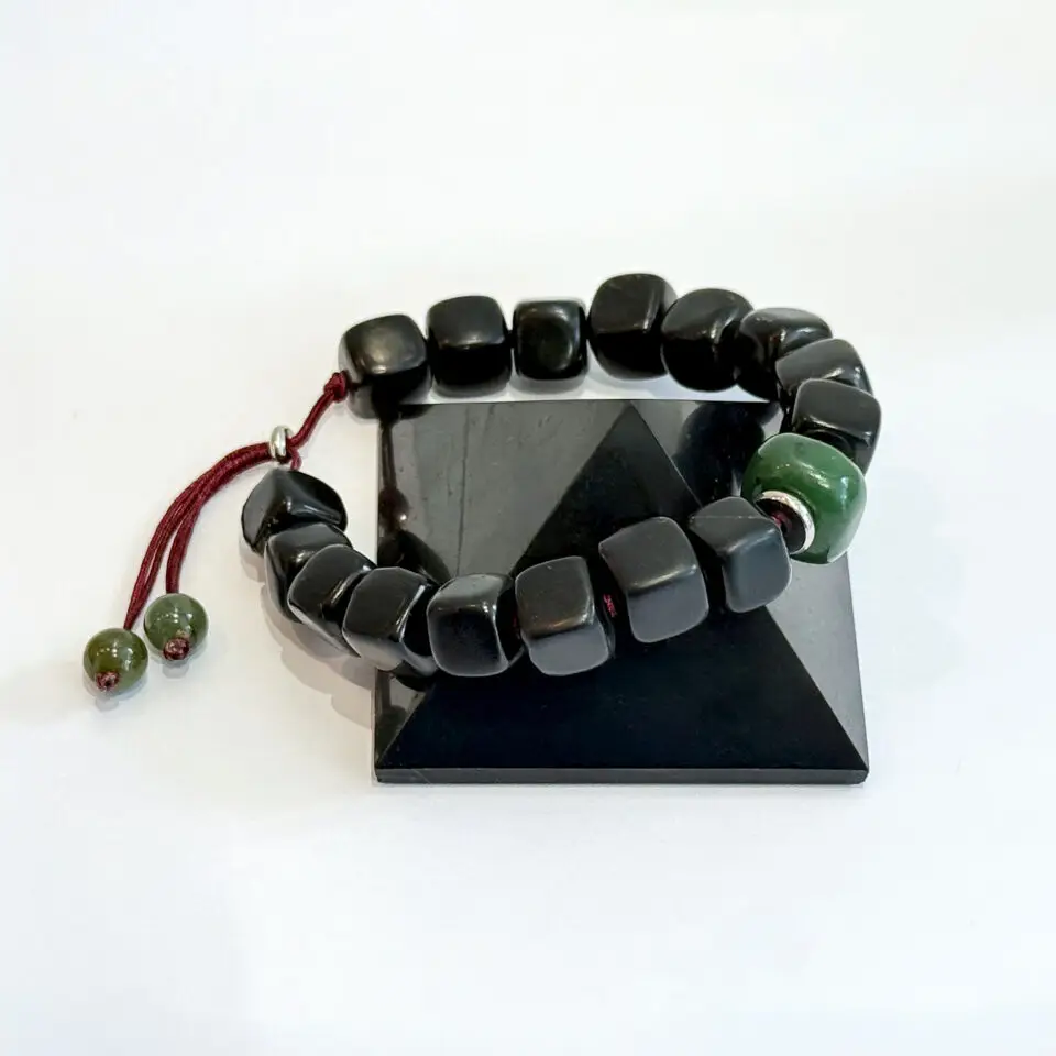 Mise en scène du bracelet Shungite & Jade avec une touche de Bordeaux